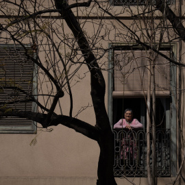 Una mujer asomada a la ventana, a 25 de abril de 2023, en Barcelona, Catalunya (España).