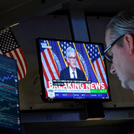 Un operador de la Bolsa de Nueva York (NYSE, por sus siglas en inglés), en Wall Street, sigue la comparecencia del presidente de la Fed, Jerome Powell, tras mantener sin cambios los tipos de interés.
