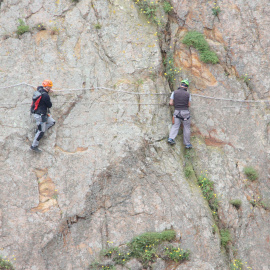 Dos escaladors fent el tram més difícil de la via ferrada de Sant Feliu de Guíxols.