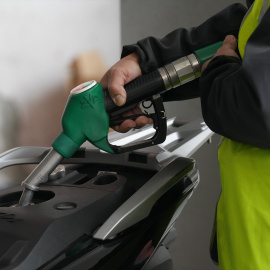 Una persona echando combustible a un vehículo.