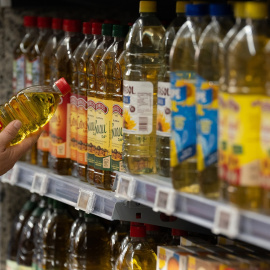 Imagen de archvio de una persona cogiendo una botella de aceite.