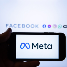 Una persona sujeta un móvil con el logo de Meta.