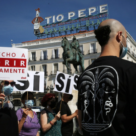 Un grupo de personas se reúne sosteniendo pancartas y carteles durante la concentración de la asociación Derecho a Morir Dignamente (DMD)