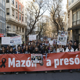Manifestantes sujetando la pancarta que pide que Mazón vaya a prisión.