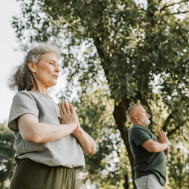 Dos personas practican taichí al aire libre.
