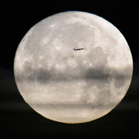 Imagen de archivo de un avión comercial frente la luna llena.