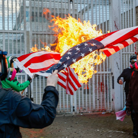 Manifestantes queman una bandera de Estados Unidos en una protesta contra el ICE en Portland