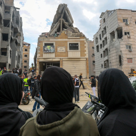 Periodistas y ciudadanos congregados alrededor de un edificio alcanzado por los ataques aéreos israelíes en los suburbios del sur de Beirut, Líbano.(1)