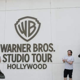 Fotografía de archivo del 21 de octubre de 2025 que muestra a personas posando frente al lugar donde se realiza el recorrido por los estudios Warner Bros. de Burbank, California.