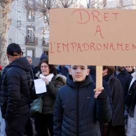 Un nen amb un cartell reclamant el dret a l'empadronament a Ripoll