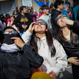 Varias personas miran arriba para observar un eclipse.