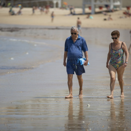 Personas paseando en la playa de La Caleta, que ha recibido la Bandera Azul, distintivo de que otorga la Fundación Europea de Educación Ambiental (FEE)