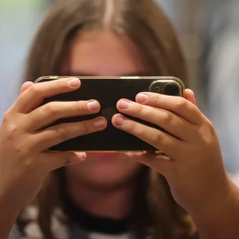 Una chica consulta su teléfono móvil.