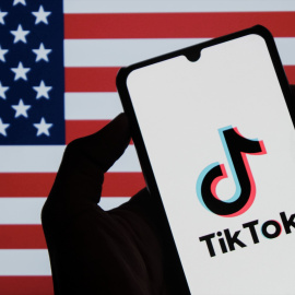 Foto de archivo del logo de Tiktok con una bandera estadounidense de fondo.