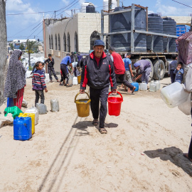 Palestinos desplazados, incluidos niños y mujeres, intentan recoger agua de un camión cisterna móvi, al sur de la Franja de Gaza.