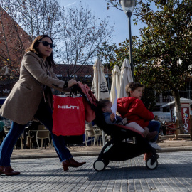 Mujer lleva un carrito de bebé.