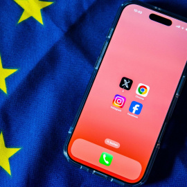 Los logotipos de Facebook, Instagram, X y Google Chrome en la pantalla de un teléfono sobre una bandera de la UE.