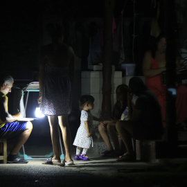 Personas esperan durante un apagón este jueves, en La Habana (Cuba)