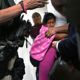 Una niña se aferra a su padre mientras agentes del ICE lo detienen, en Nueva York.