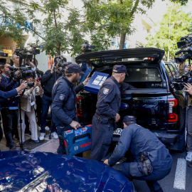 Agentes de la Policía Nacional guardan material incautado durante el registro a la oficina del expresidente del Gobierno José Luis Rodríguez Zapatero en Madrid.