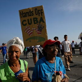 Una persona sostiene un cartel el Primero de Mayo frente a la Embajada de Estados Unidos, en La Habana, Cuba.