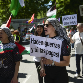 Manifestantes portan pancarta con lema 'Hacen guerras y tú las pagas' durante una manifestación pro Palestina.