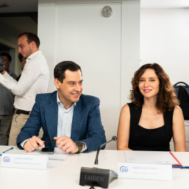 El presidente de la Junta de Andalucía, Juanma Moreno, y la presidenta de la Comunidad de Madrid, Isabel Díaz Ayuso, durante una reunión en la sede del PP.