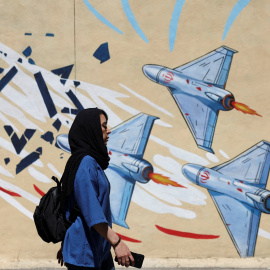 Una mujer iraní camina junto a un mural antiisraelí en una calle de Teherán el 26 de mayo de 2026.
