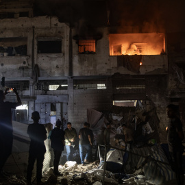 Palestinos inspeccionan el lugar de un ataque israelí contra un edificio residencial que albergaba a personas desplazadas en la ciudad de Gaza.