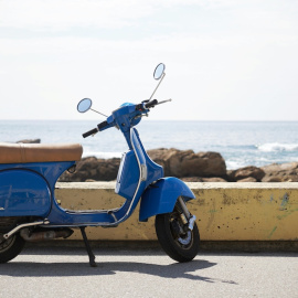 Imagen de una Vespa azul aparcada en Portugal.