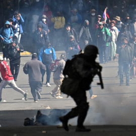 Un policía corre hacia los manifestantes en una protesta que pide la dimisión del presidente de Bolivia, Rodrigo Paz, a 25 de mayo de 2026.