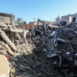 Varios palestinos inspeccionan los escombros de un edificio destruido por un ataque aéreo israelí.