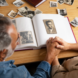 Personas mirando un álbum de fotografías.