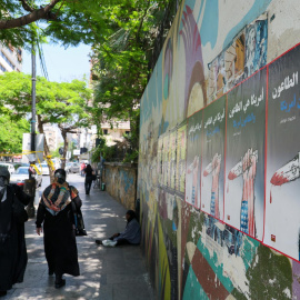 Dos mujeres caminan junto a carteles con propaganda antiestadounidense este martes en Beirut (Líbano).