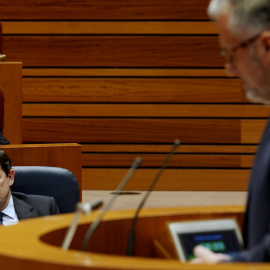Fernández Mañueco atiende a la intervención del portavoz de Vox, Carlos Pollán, durante el debate de investidura este martes.