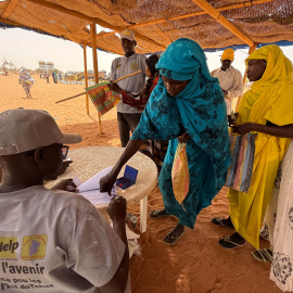 Una mujer en el campo de refugiados de Aboutengue, Chad, recibiendo su ración de comida.