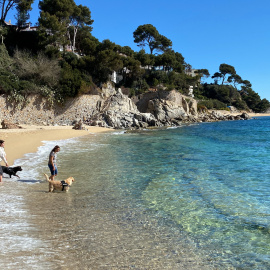 Dues noies amb els seus gossos en una platja empordanesa