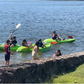 Captura de pantalla de un vídeo en el que se observa a niños jugando y navegando en piragua en una de las zonas de As Conchas contaminadas por cianobacterias.