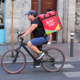 Fotografía de un repartidor de Just Eat en bicicleta por una calle del centro de Madrid (foto de archivo).