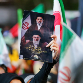 Una mujer iraní levanta un retrato del actual líder supremo, Ayatollah Mojtaba Khamenei, junto a su predecesor.