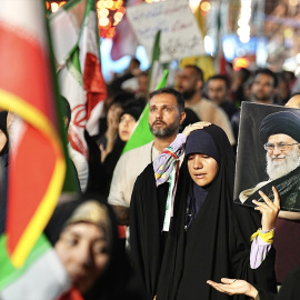 Una persona sostiene un retrato del ayatolá en una manifestación organizada por el estado de Irán.