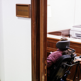 Una persona afectada de ELA (esclerosis lateral amiotrófica) registrando la petición de que se desbloquee la tramitación de la Ley ELA, en 2023