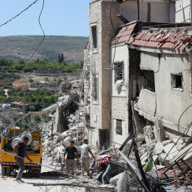 Personas retiran los escombros de edificios cercanos tras un ataque israelí sobre el municipio de Qlaileh, al sur del Líbano.