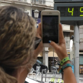 Una mujer fotografía la temperatura de un termómetro en Granada. EFE Pepe Torres.