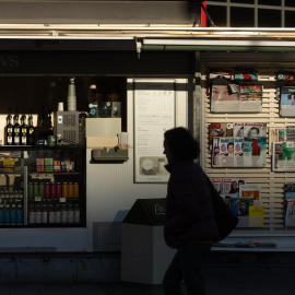 Una persona camina junto a un quiosco en Madrid (Archivo).