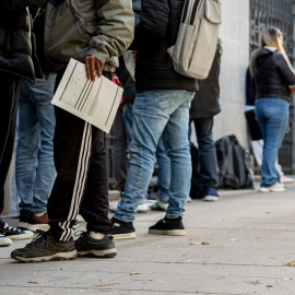 Varias personas hacen cola para solicitar los papeles necesarios para acogerse a la regularización.