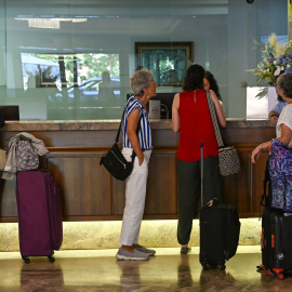 Turistas esperando para hacer el check in en un hotel de Santander, Cantabria.