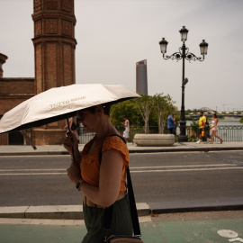 Una mujer se protege del sol en Sevilla ante la ola de calor intensa en la región.