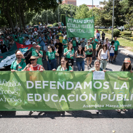 Numerosas personas sostienen una pancarta con el lema 'Defendamos la educación pública' durante una manifestación en favor de la educación pública, a 14 de junio de 2026, en Madrid.