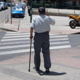 Un hombre mayor pasea en Madrid apoyándose en un bastón. Archivo.